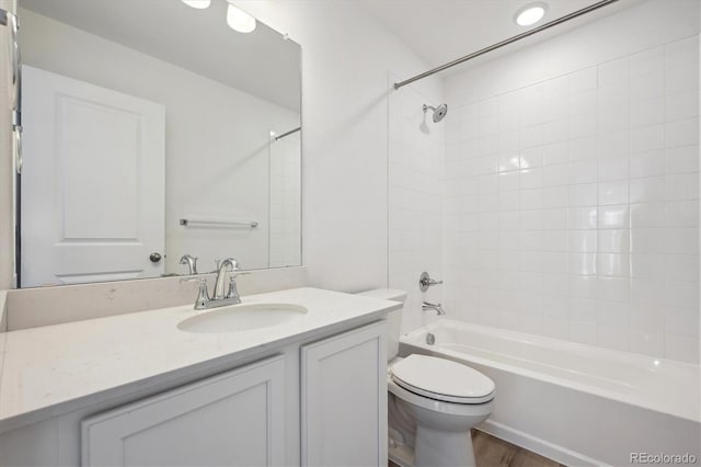 full bathroom with tiled shower / bath combo, vanity, and toilet