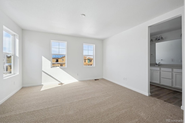 unfurnished living room featuring a healthy amount of sunlight and light colored carpet