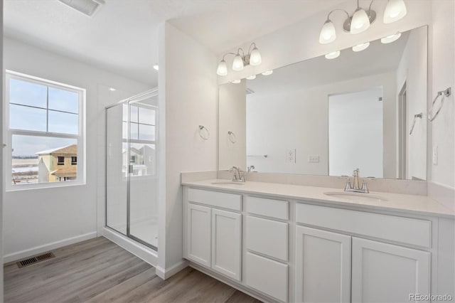 bathroom with hardwood / wood-style floors, vanity, and walk in shower