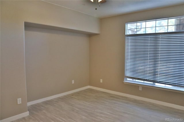 empty room with ceiling fan and light hardwood / wood-style floors