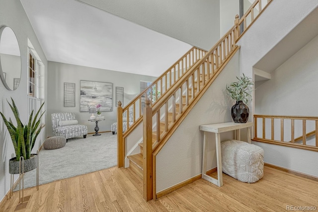 stairs with wood finished floors and baseboards
