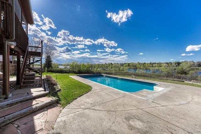 view of pool with stairs, a patio area, fence, and a water view