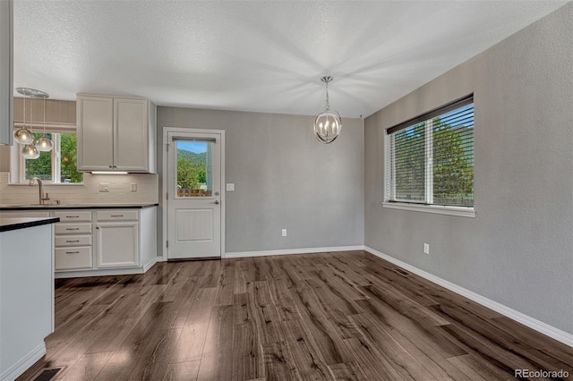 201 S Boundary St, Woodland Park, CO 80863 - kitchen with dark countertops, plenty of natural light, a chandelier, and dark wood-style floors