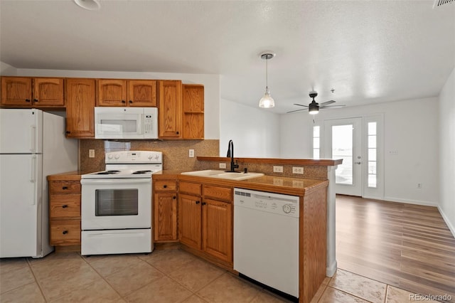 5425 County Road 32 Unit 14, Mead, CO 80504 - kitchen featuring white appliances, a sink, a peninsula, and brown cabinetry