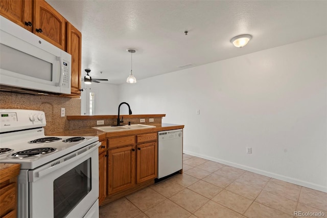 5425 County Road 32 Unit 14, Mead, CO 80504 - kitchen with white appliances, a sink, a peninsula, brown cabinetry, and light tile patterned floors