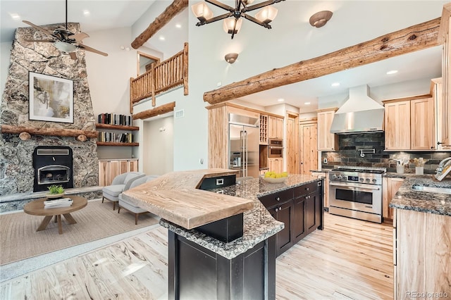 kitchen with a center island, wall chimney exhaust hood, decorative backsplash, beam ceiling, and high quality appliances