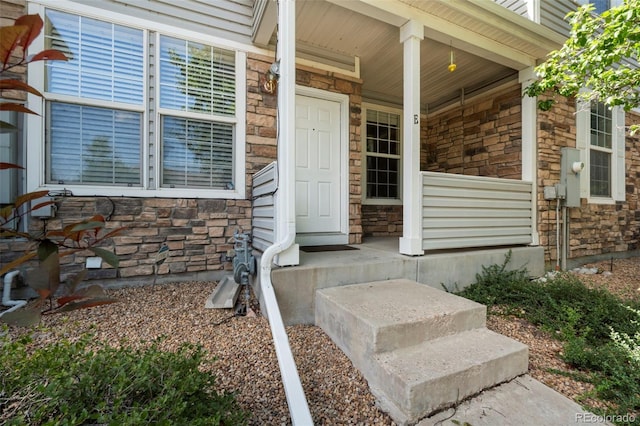 12778 Jasmine St Unit E, Thornton, CO 80602 - view of exterior entry featuring stone siding and covered porch