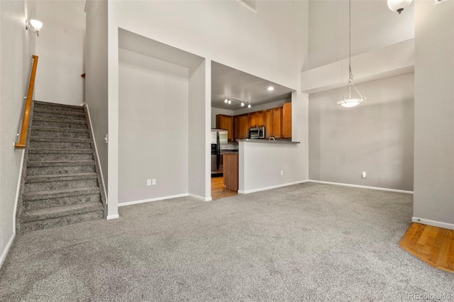12778 Jasmine St Unit E, Thornton, CO 80602 - unfurnished living room featuring stairway and carpet floors
