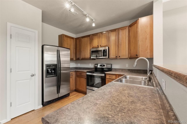 12778 Jasmine St Unit E, Thornton, CO 80602 - kitchen with stainless steel appliances, light wood-type flooring, and brown cabinetry