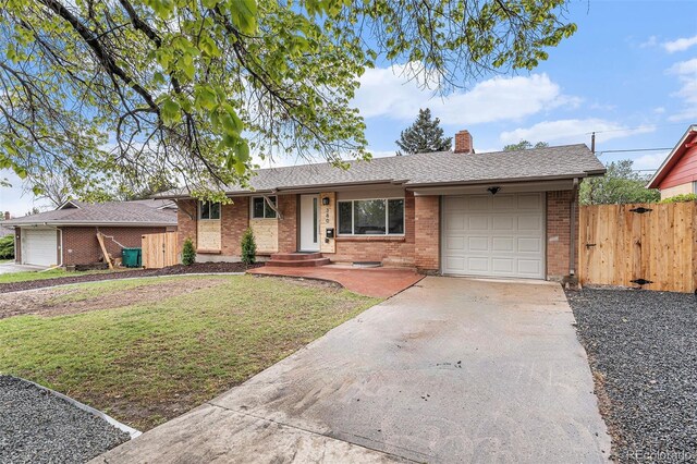 view of front of house featuring an attached garage, driveway, brick siding, and a chimney