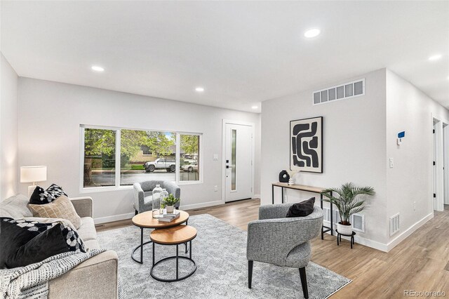living area featuring light wood-style flooring, recessed lighting, and baseboards
