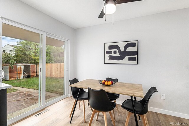 dining room featuring light wood finished floors, a ceiling fan, and baseboards