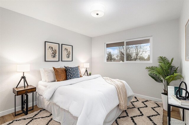 bedroom featuring baseboards and wood finished floors