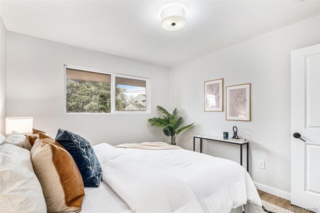 bedroom with wood finished floors and baseboards