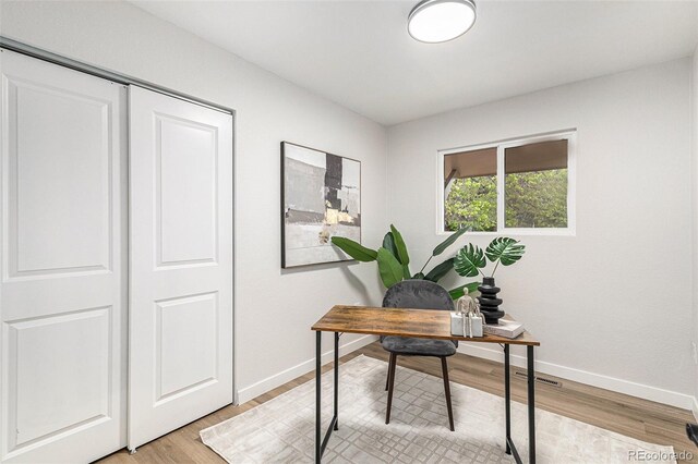 office area with light wood-style floors and baseboards