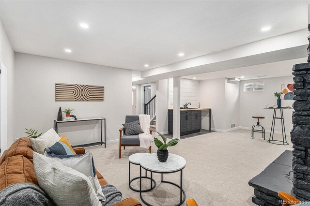 carpeted living area featuring recessed lighting, stairway, baseboards, and a sink