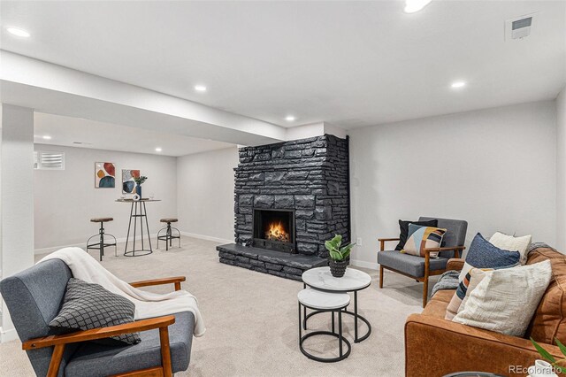 living room featuring light colored carpet, recessed lighting, a fireplace, and baseboards