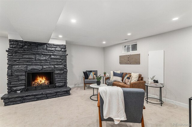 living room with light carpet, recessed lighting, a stone fireplace, and baseboards