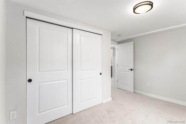 unfurnished bedroom with carpet, baseboards, and a closet