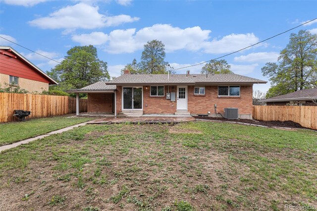 rear view of property featuring cooling unit, brick siding, a chimney, and a patio area