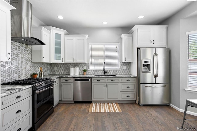 3775 Balderas St, Brighton, CO 80601 - kitchen with appliances with stainless steel finishes, wall chimney exhaust hood, decorative backsplash, dark wood-style flooring, and light stone countertops
