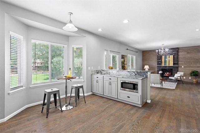 3775 Balderas St, Brighton, CO 80601 - kitchen featuring stainless steel microwave, plenty of natural light, a lit fireplace, dark wood-style floors, and recessed lighting