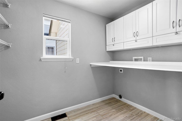 3775 Balderas St, Brighton, CO 80601 - laundry room with hookup for an electric dryer, cabinet space, light wood finished floors, and washer hookup