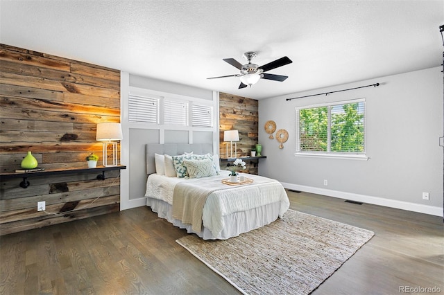 3775 Balderas St, Brighton, CO 80601 - bedroom featuring wood walls, wood finished floors, an accent wall, and a ceiling fan