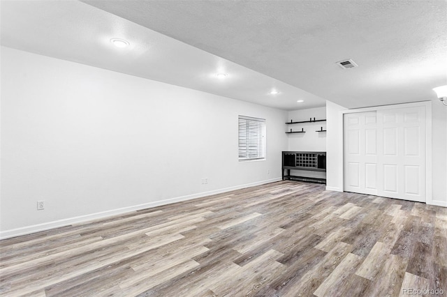 3775 Balderas St, Brighton, CO 80601 - unfurnished living room featuring wood finished floors, a textured ceiling, and recessed lighting