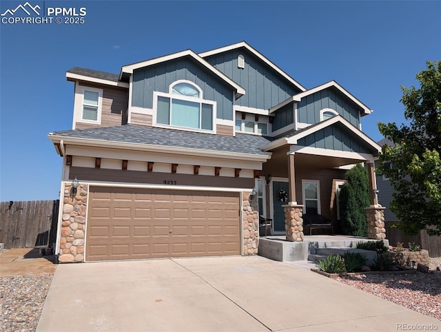 9233 Waters Edge Dr, Fountain, CO 80817 - view of front facade featuring roof with shingles, an attached garage, driveway, board and batten siding, and stone siding