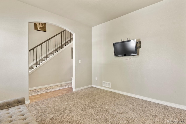 9233 Waters Edge Dr, Fountain, CO 80817 - unfurnished living room featuring arched walkways, carpet, and stairway