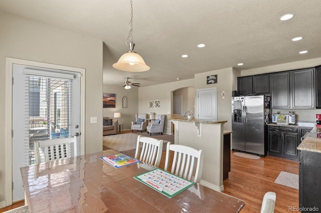 9233 Waters Edge Dr, Fountain, CO 80817 - dining room with a ceiling fan, recessed lighting, arched walkways, light wood-type flooring, and a textured ceiling