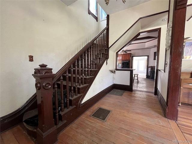 staircase with a high ceiling and hardwood / wood-style flooring