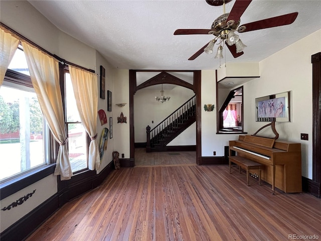 entryway with a textured ceiling, dark hardwood / wood-style floors, and ceiling fan with notable chandelier