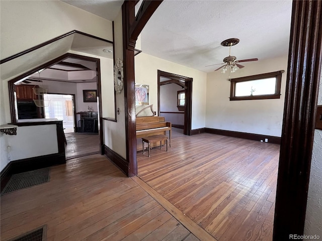 corridor featuring dark hardwood / wood-style floors, plenty of natural light, and a textured ceiling