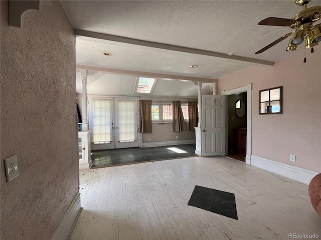 foyer entrance featuring a textured ceiling, french doors, vaulted ceiling with beams, hardwood / wood-style flooring, and ceiling fan