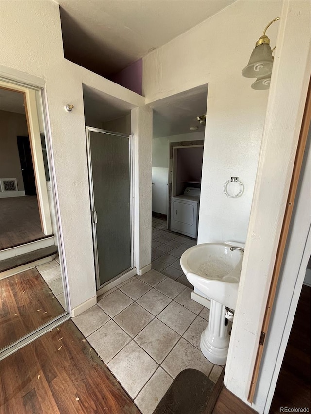 bathroom featuring walk in shower, tile floors, and washer / clothes dryer