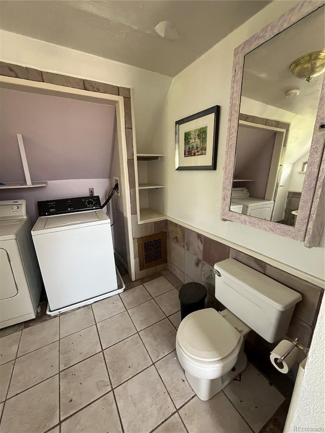 bathroom with separate washer and dryer, toilet, and tile floors