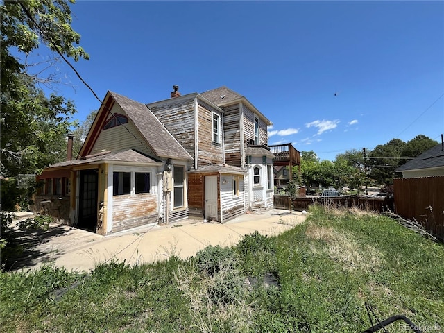 rear view of property featuring a balcony and a patio