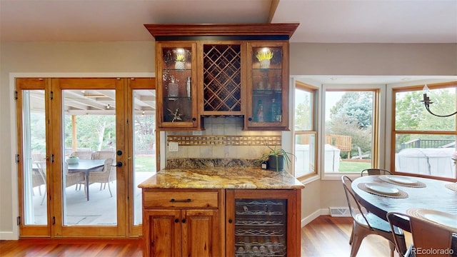 6278 E Euclid Ave, Centennial, CO 80111 - indoor dry bar featuring wine cooler, light wood finished floors, decorative backsplash, and healthy amount of natural light