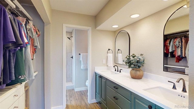 6278 E Euclid Ave, Centennial, CO 80111 - bathroom featuring double vanity, toilet, walk in shower, wood finished floors, and a walk in closet