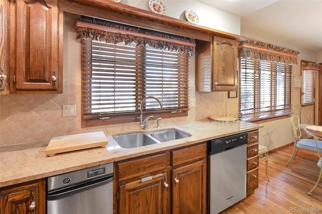 kitchen featuring light stone counters, sink, decorative backsplash, and dishwasher