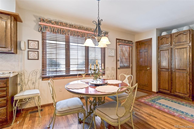 dining area featuring an inviting chandelier and light hardwood / wood-style floors