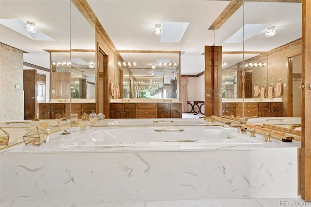 bathroom with tiled tub, vanity, and a skylight