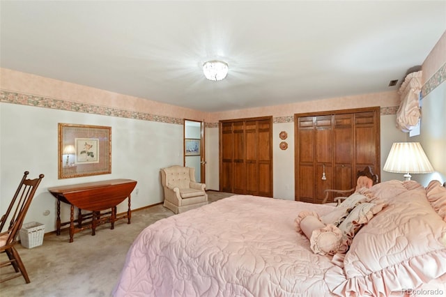 carpeted bedroom featuring two closets