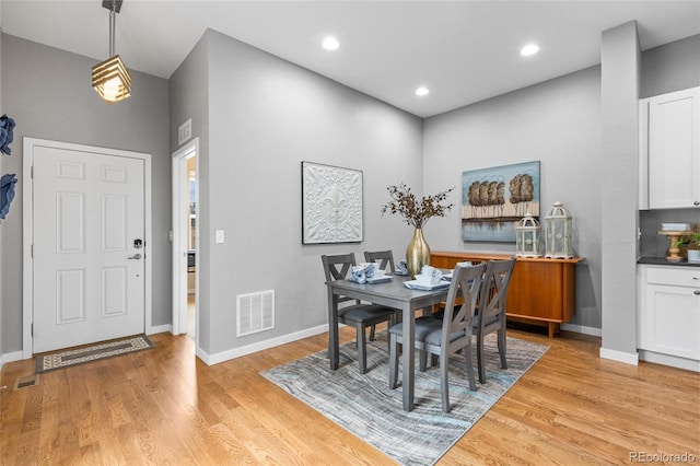 dining space featuring light wood-style flooring, visible vents, and baseboards