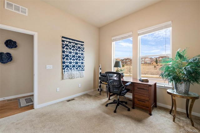 office area featuring baseboards, visible vents, and light colored carpet