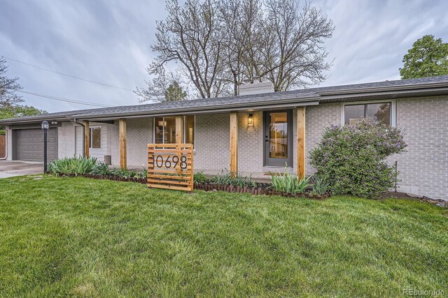 10698 W 26th Ave, Lakewood, CO 80215 - view of front of property with brick siding, an attached garage, a front lawn, a chimney, and covered porch