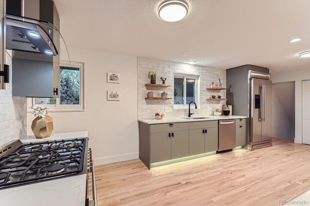10698 W 26th Ave, Lakewood, CO 80215 - kitchen with appliances with stainless steel finishes, a sink, light wood finished floors, and backsplash