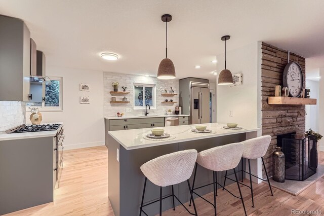 10698 W 26th Ave, Lakewood, CO 80215 - kitchen featuring a sink, stainless steel appliances, a peninsula, open shelves, and tasteful backsplash